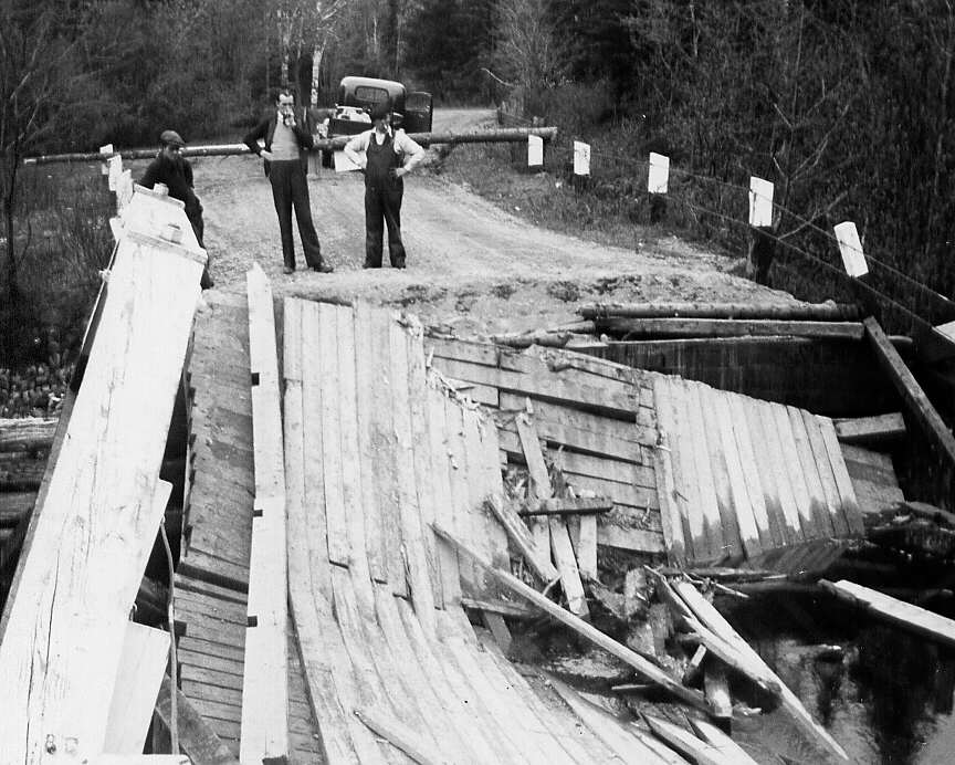 Trois hommes constatent l'écroulement du pont de la route 8 à Eardley dans le comté de Gatineau en 1947