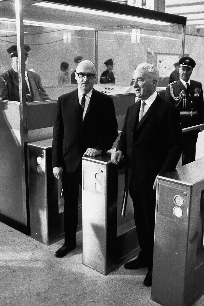 Jean Drapeau et un dignitaire utilisant les barrières d'accès au métro de Montréal lors de l'inauguration du métro en 1966
