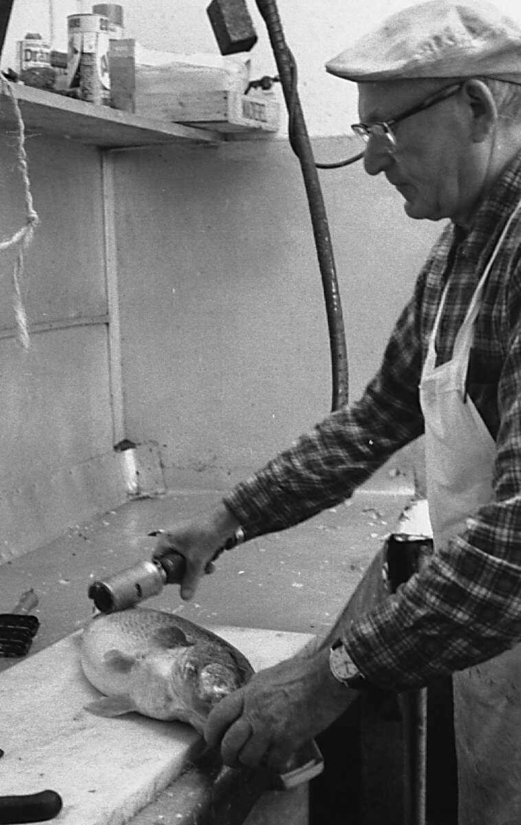 Homme au travail dans une poissonnerie polonaise à Montréal